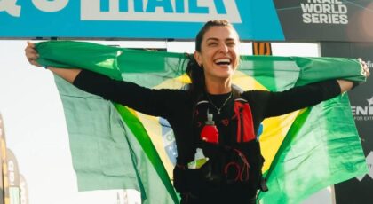 Imagem de Bruna Ianhez segurando uma bandeira do Brasil na linha final da corrida