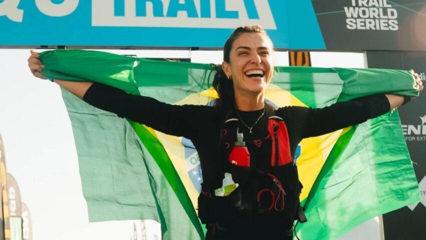 Imagem de Bruna Ianhez segurando uma bandeira do Brasil na linha final da corrida